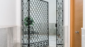 A hallway with a black decorative metal gate, a wooden door, and a marble floor. - San Lorenzo 5 - One Bedroom Apartment, Sleeps 4 (Sevilla)