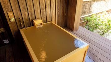 Una bañera de hidromasaje de madera con una terraza de madera alrededor.