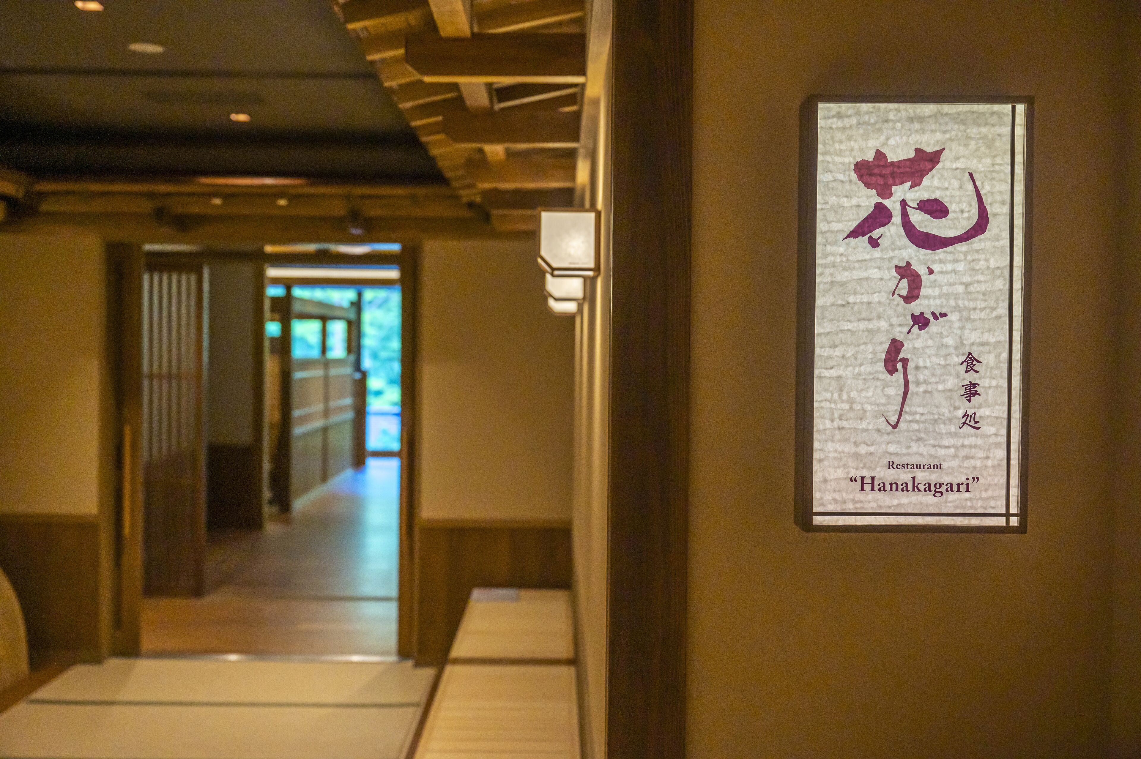 A hallway with a framed sign for "Hanagari Restaurant" on the wall.