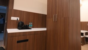 A modern kitchen with wooden cabinets, a countertop, and a kettle. - Fairvacanze Inns & Suites Lucknow (Lucknow)