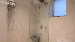 A modern bathroom with a glass-enclosed shower, a toilet, and a sink. - Fairvacanze Inns & Suites Lucknow (Lucknow)