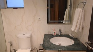 A bathroom with a toilet, sink, mirror, and a TV mounted on the wall. - Fairvacanze Inns & Suites Lucknow (Lucknow)