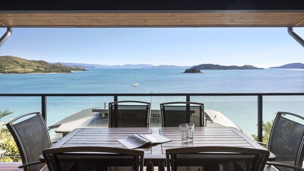 A table with chairs and a view of the sea. - Shorelines 27 Hamilton Island - oceanviews, golf buggy and transfers (Hamilton Island)