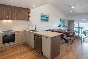 Une cuisine moderne dotée d’appareils électroménagers intégrés, un coin repas avec vue et un ventilateur de plafond.