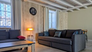 Ett modernt vardagsrum med en väggpanel av trä, en soffa, ett soffbord och en golvlampa.