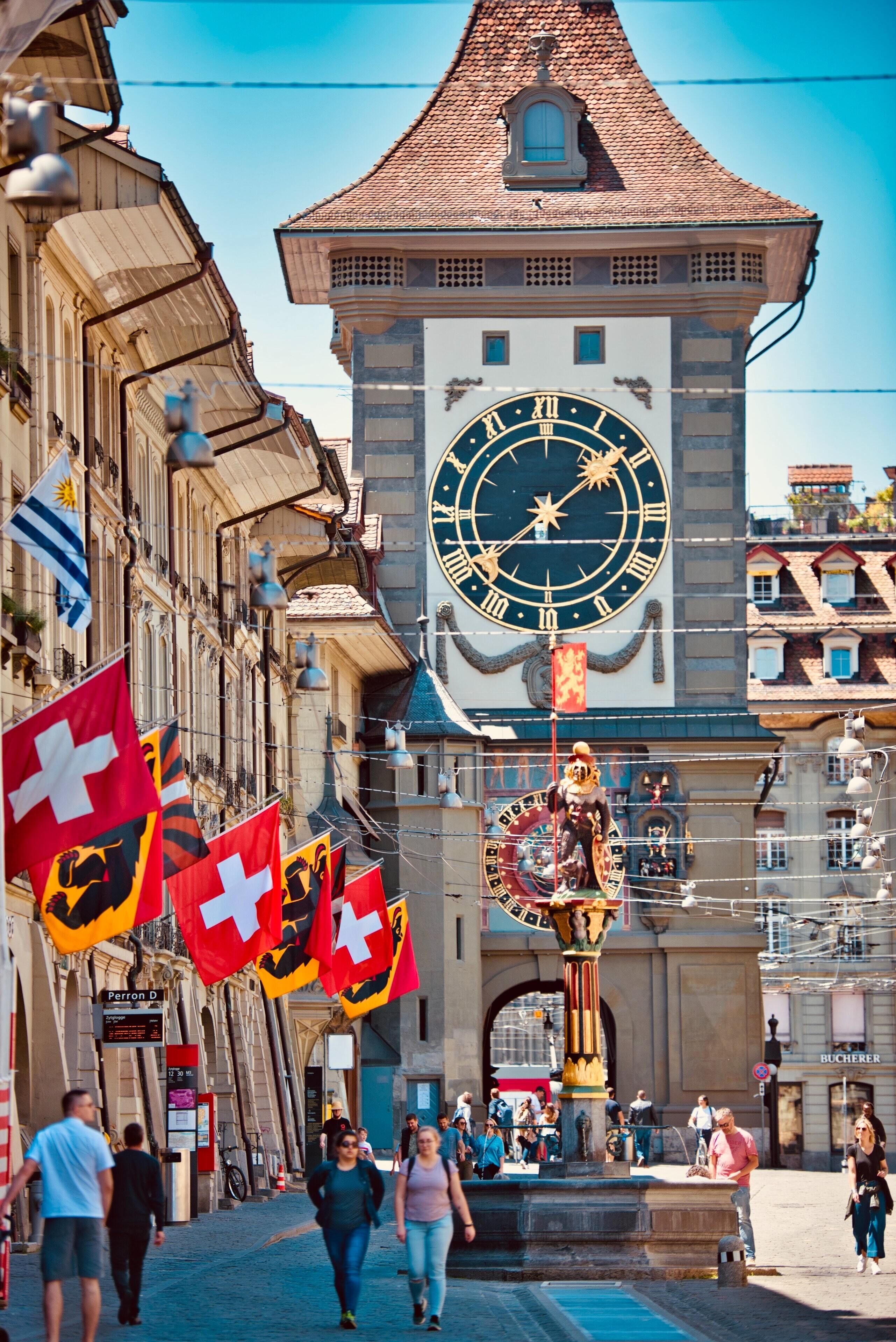 A historic building with a prominent clock tower and flags.