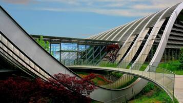 A modern architectural structure with a curved bridge and glass panels.