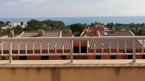A balcony with a view of a coastal town, terracotta-tiled buildings, and a clear sky. - Magnificent Duplex with Pool in L'Ametlla de Mar (L'Ametlla de Mar)