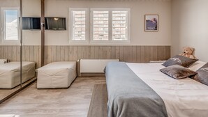 A bedroom with a bed, two seating areas, a television, windows, and a teddy bear. - PREMIUM Studio in Tignes, 2 people, WIFI included (Tignes)