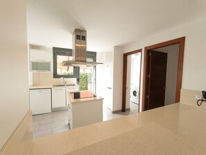 Una cucina moderna con forno a incasso, lavello e finestra vista giardino.