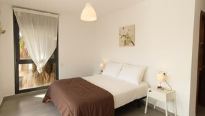 A bedroom with a bed, bedside tables, a hanging light fixture, a window with curtains, and a wall-mounted picture. - Villa with Private Pool, 100m from Sea, Spacious Garden, Near Calafat in Costa Dorada (L'Ametlla de Mar)