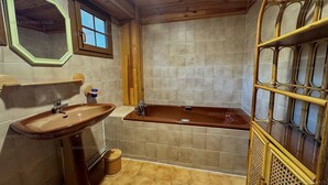A bathroom with a wooden ceiling, a large window, a sink, a bathtub, and a decorative wooden shelf. - 4-sided Cottage 80m² near lake with garage (Matemale)