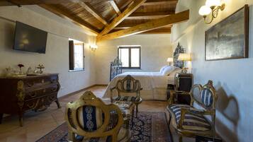 Quarto com cama, móveis de madeira, televisão e um quadro.
