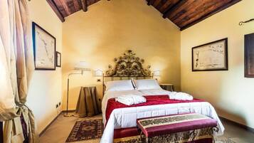Un dormitorio con una cama grande, techo de madera y dos cuadros en las paredes.