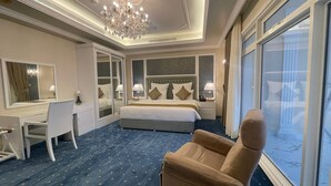 Habitación de hotel con una cama grande, un escritorio, una silla y vistas al exterior.