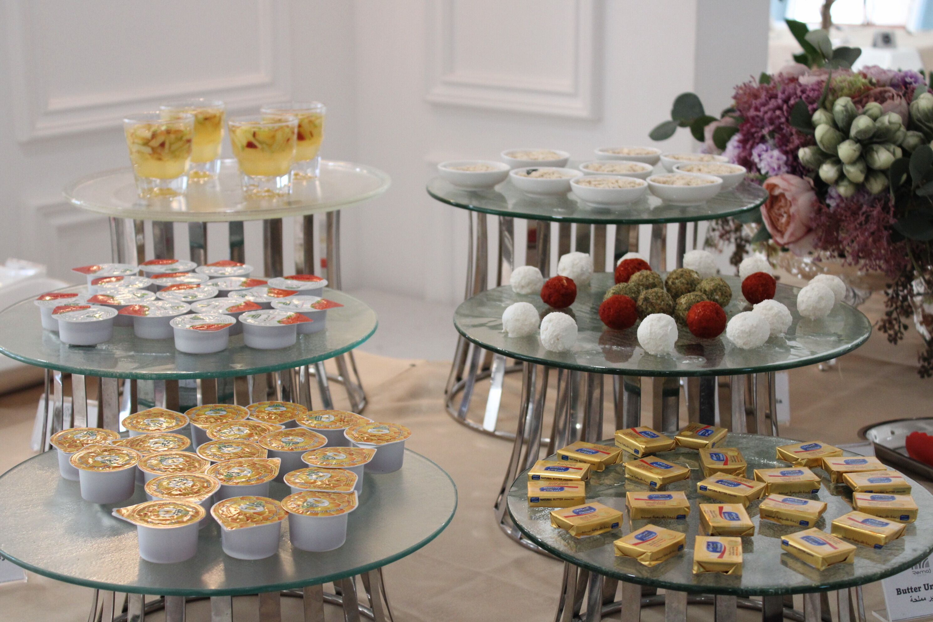 Un buffet proposant une variété de plats et de desserts, le tout présenté sur des tables en verre.
