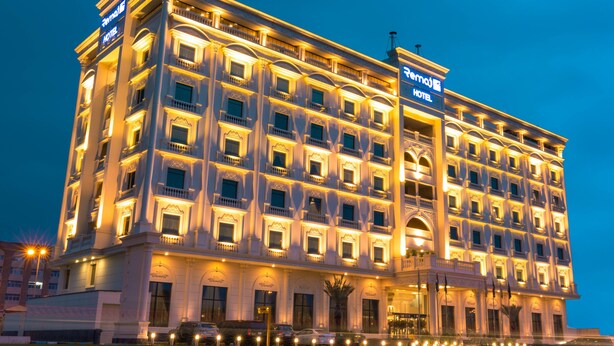 A large, multi-story hotel with a classic architectural style, featuring numerous balconies and a well-lit facade. - Remaj Hotel (Taif)