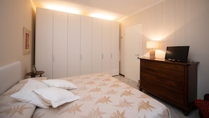 A bedroom with a bed, a dresser, a television, and a lamp. - Appartamento Maria Cristina (Polpenazze del Garda)
