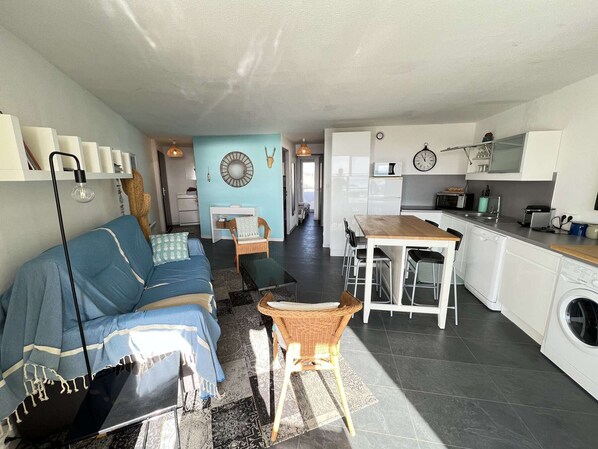 A modern apartment with a living room, dining area, and kitchen.