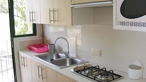 Cocina compacta con lavabo, estufa y microondas.