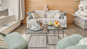 A cozy living room with a sofa, a coffee table, and a teddy bear. - Premium Apartment in Tignes for 6 ppl with WIFI (Tignes)