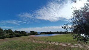 Zona verde con piscina y un sendero de piedra.