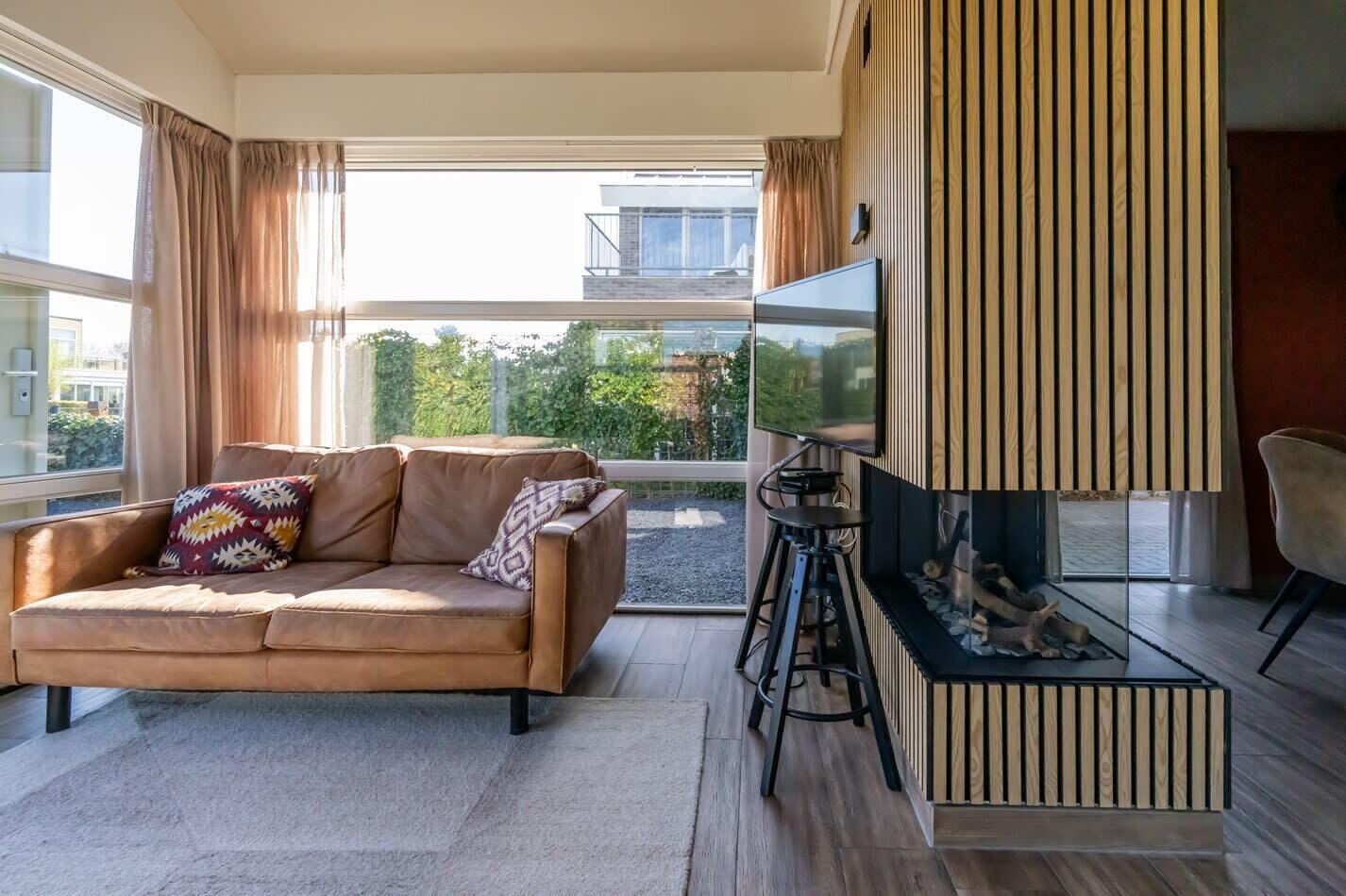 Una sala de estar moderna con un sofá, un televisor y una chimenea.
