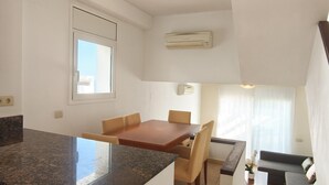 A compact living space with a kitchen area, dining table, and seating.