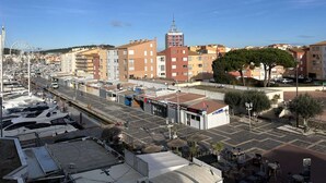 A marina with yachts docked, a Ferris wheel, and buildings with balconies. - Charming Studio with Pool, Balcony, and Central Location for 2 in Agde (Cap d'Agde)