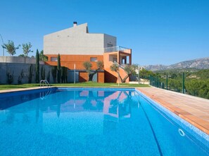 Une maison moderne à deux étages avec une piscine à l’avant.