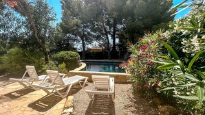 A poolside area with lounge chairs, a swimming pool, and surrounding greenery. - Charming Rustic Villa with Pool & Mediterranean Garden (L'Ametlla de Mar)