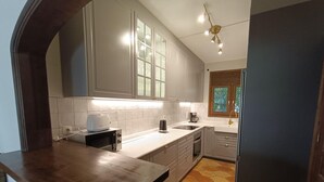 A kitchen with white cabinets, a countertop, a toaster, a coffee maker, and a sink. - Charming Rustic Villa with Pool & Mediterranean Garden (L'Ametlla de Mar)