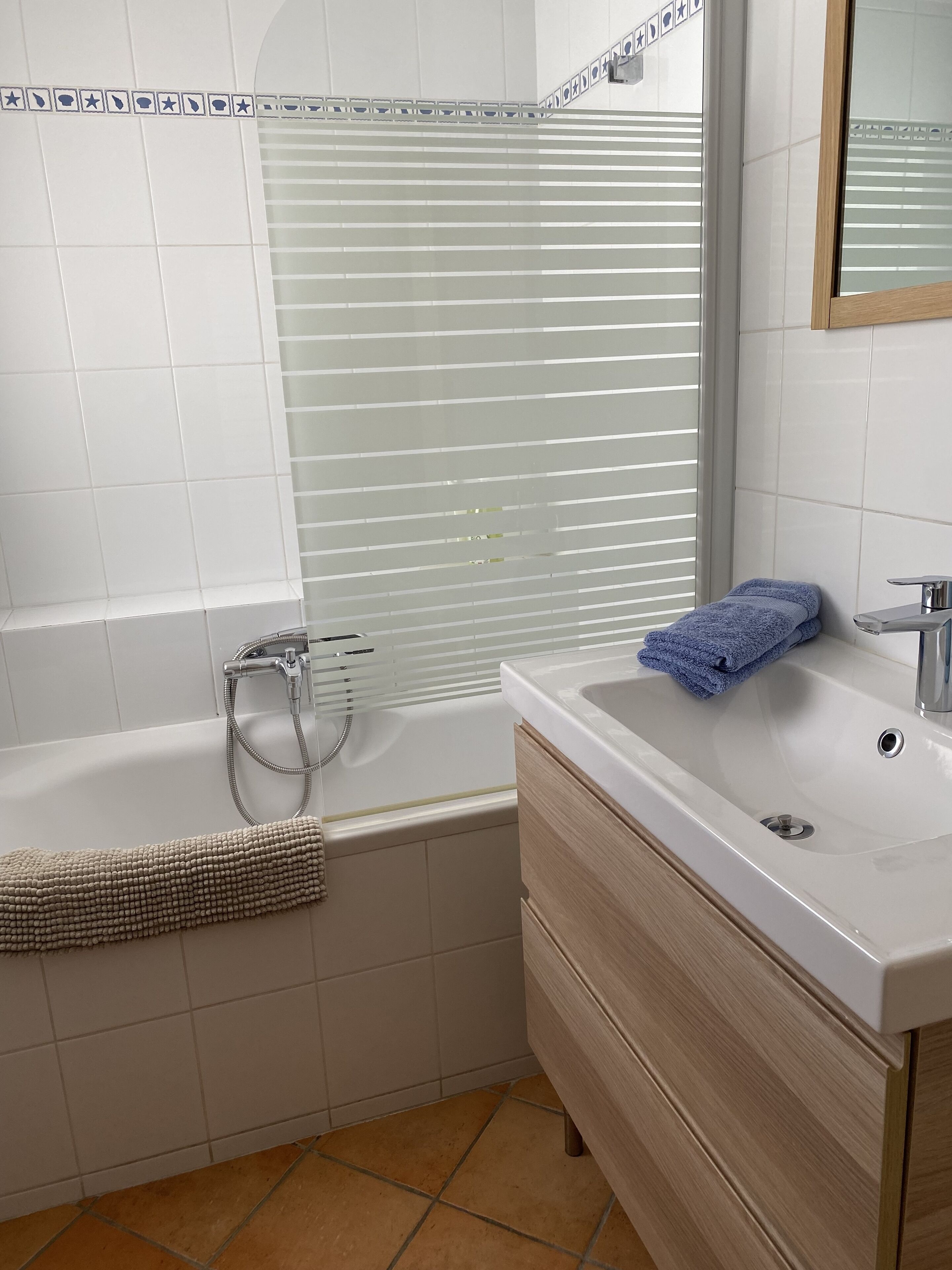 Een moderne badkamer met een badkuip, een wastafel en een badkamerkast.