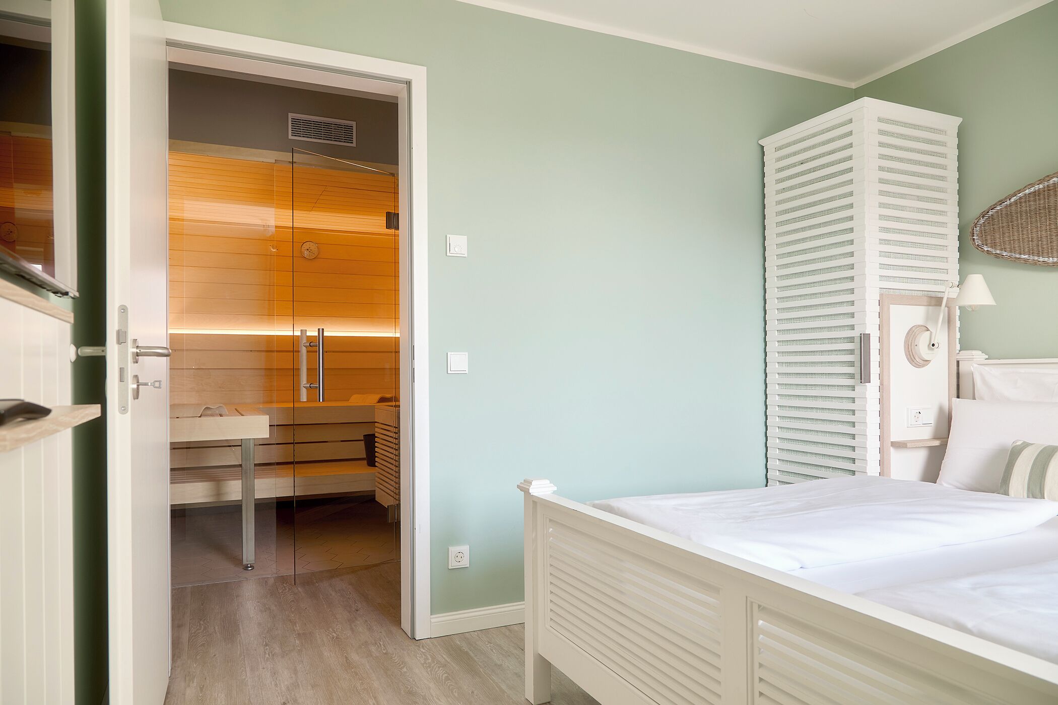 A bedroom with a bed, a wardrobe, and a bathroom visible through an open door.