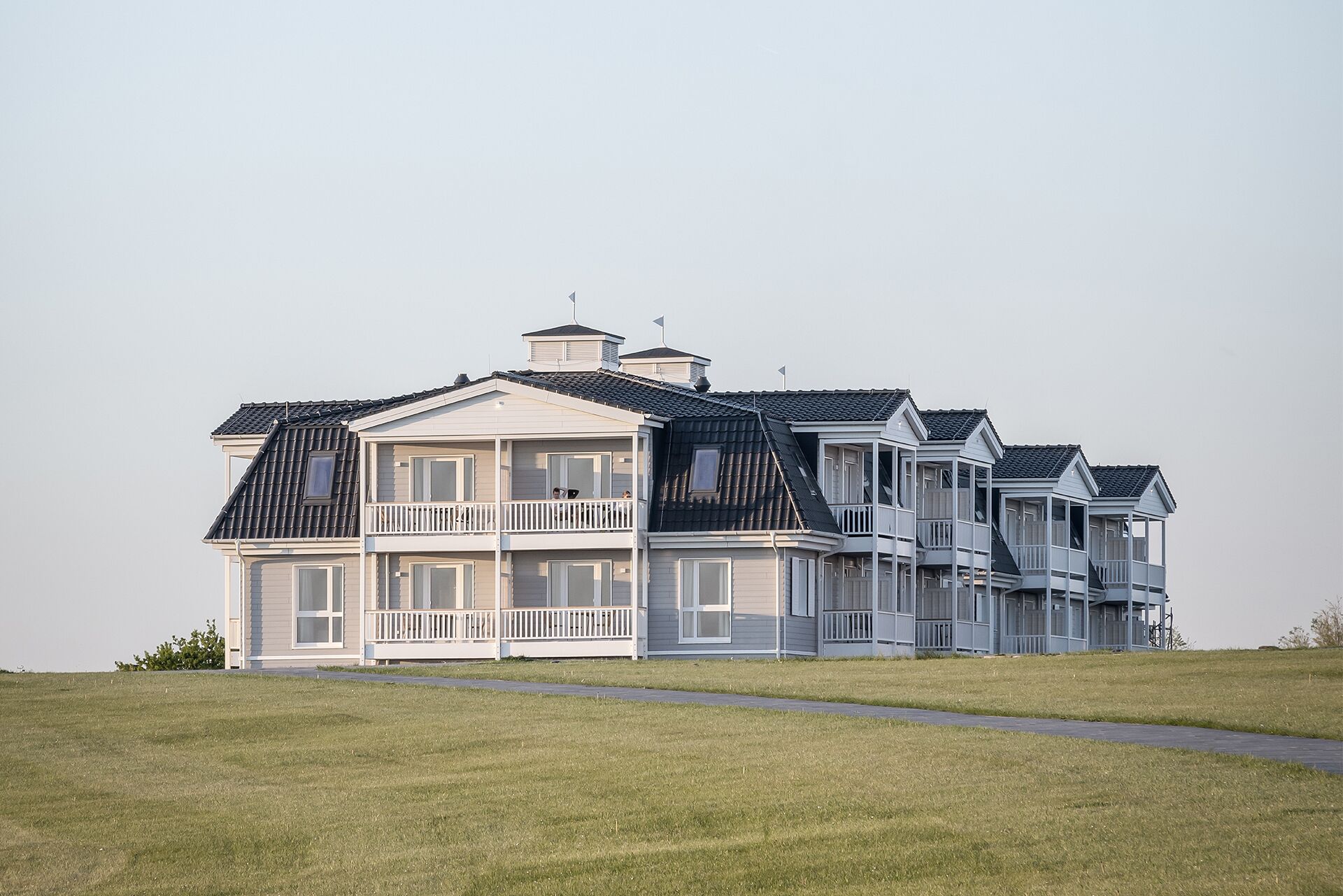 A large, multi-story house with a prominent balcony on the second floor.