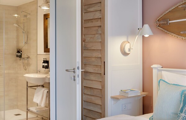 Une salle de bain moderne avec une douche à parois de verre, un lavabo blanc et un panneau mural en bois.