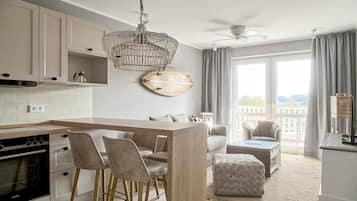 Une cuisine moderne avec un îlot central en bois, des tabourets de bar et un luminaire suspendu.