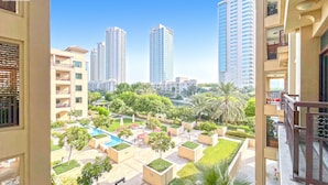 Edificio residencial de varios pisos, con balcones y un patio interior con vegetación y una piscina.