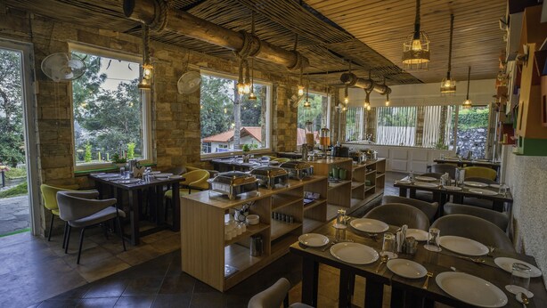 A restaurant with multiple dining areas, wooden tables, and chairs.