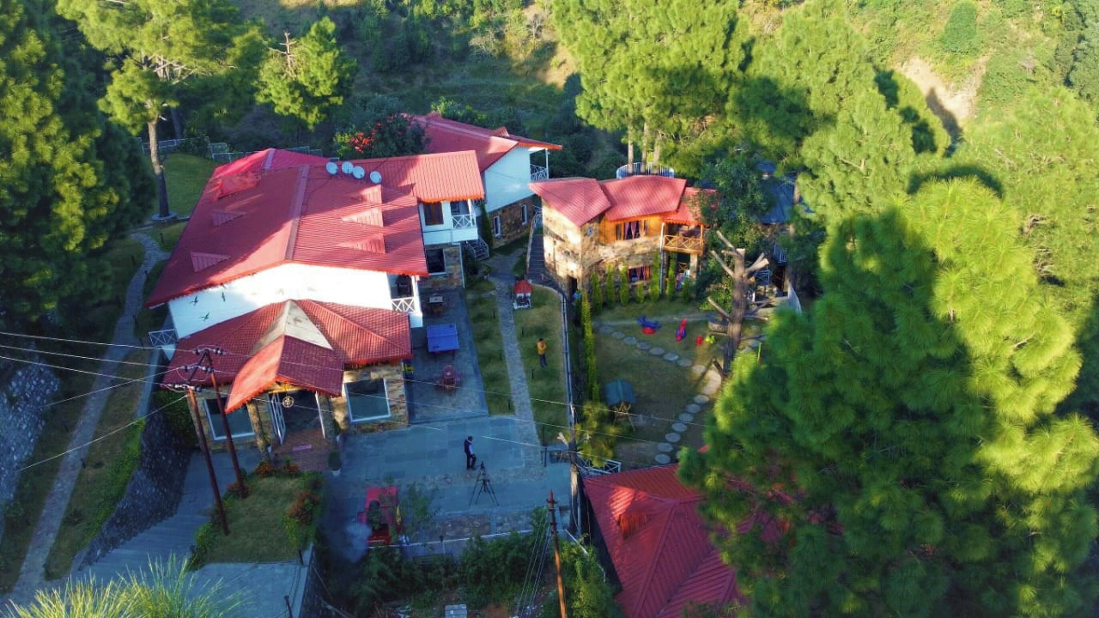 Una zona residencial con varias casas, cada una con tejados rojos y rodeada de vegetación.