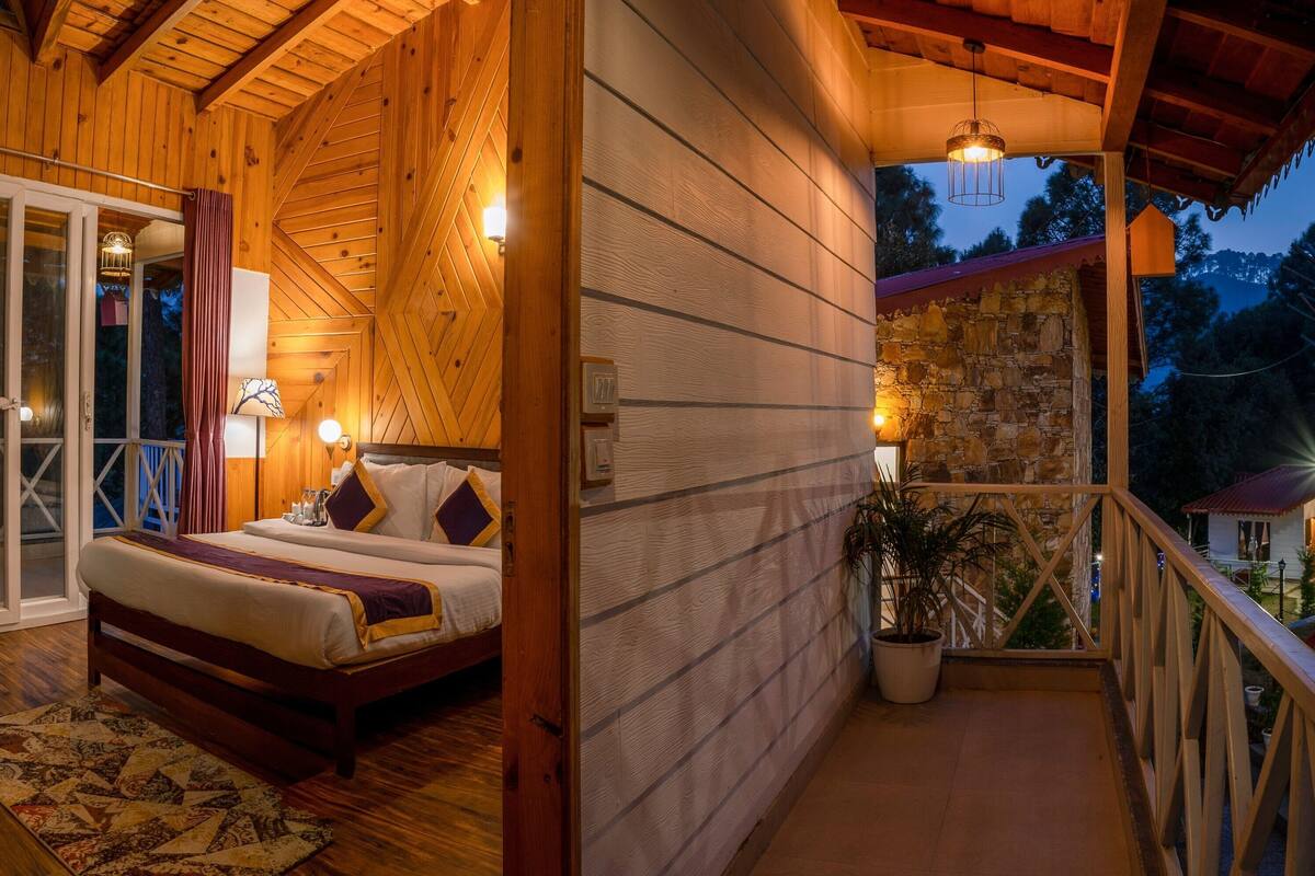 Una habitación de madera con una cama, un balcón y una pared de piedra.