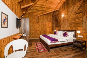 Una habitación con paneles de madera, una cama, una silla, un escritorio y un televisor.