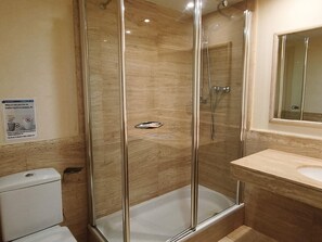 A bathroom with a glass-enclosed shower, a toilet, and a sink with a mirror above it. - Luxury Seafront Apartment for Families in L'Ametlla de Mar (L'Ametlla de Mar)