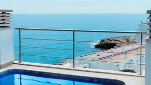 Ein Pool mit Blick auf das Meer und eine felsige Küstenlinie.