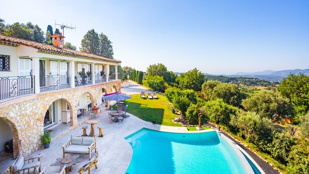 A poolside area with a stone building, outdoor seating, and a view of the countryside. - Le Clos des Senteurs (Chateauneuf-Grasse)