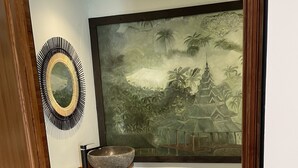A bathroom with a stone sink, a decorative mirror, and a large mural of a temple. - Le Clos des Senteurs (Chateauneuf-Grasse)