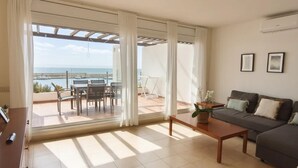 A spacious living room with a large sliding glass door leading to an outdoor patio area. - Charming Apartment with Marina View in L'Ametlla de Mar (L'Ametlla de Mar)