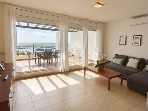 A spacious living room with a large sliding glass door leading to an outdoor patio area.