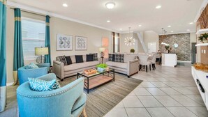 A modern living room with a sofa, armchairs, a coffee table, and a dining area. - Modern Home, Private Pool. Sleeps 15 | WW102 (Kissimmee)