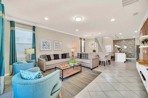 A modern living room with a sofa, armchairs, a coffee table, and a dining area. - Modern Home, Private Pool. Sleeps 15 | WW102 (Kissimmee)
